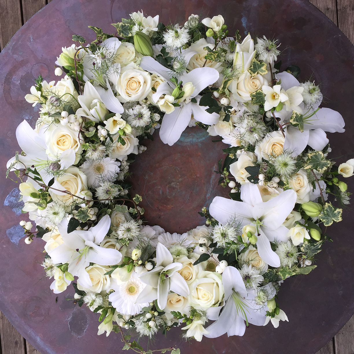 Funeral wreath with white flowers, made with white roses, lilies, eustoma