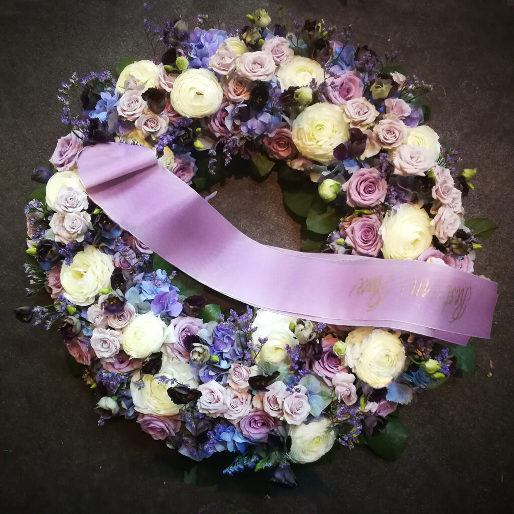 Funeral Flowers, Wreath with white, blue and purple flowers - roses and special garden flowers