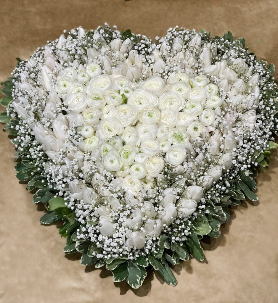 Funeral hearth with white ranunculus and different white flowers