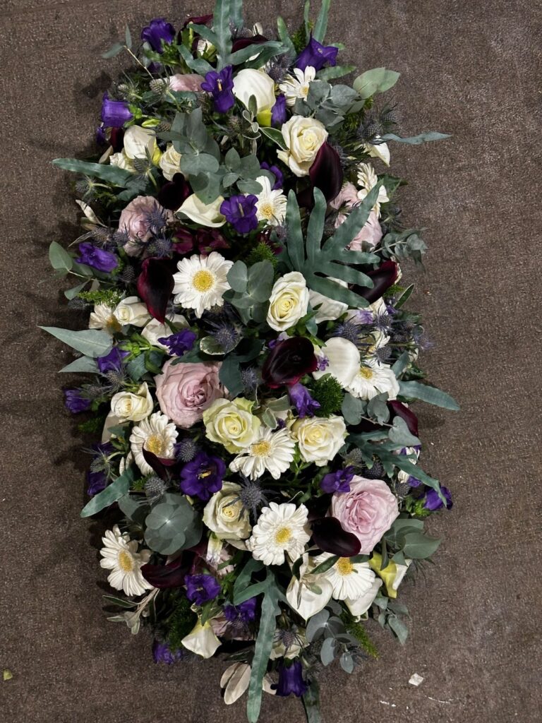 Funeral bouquet for coffin with white and lilac funeral flowers hue